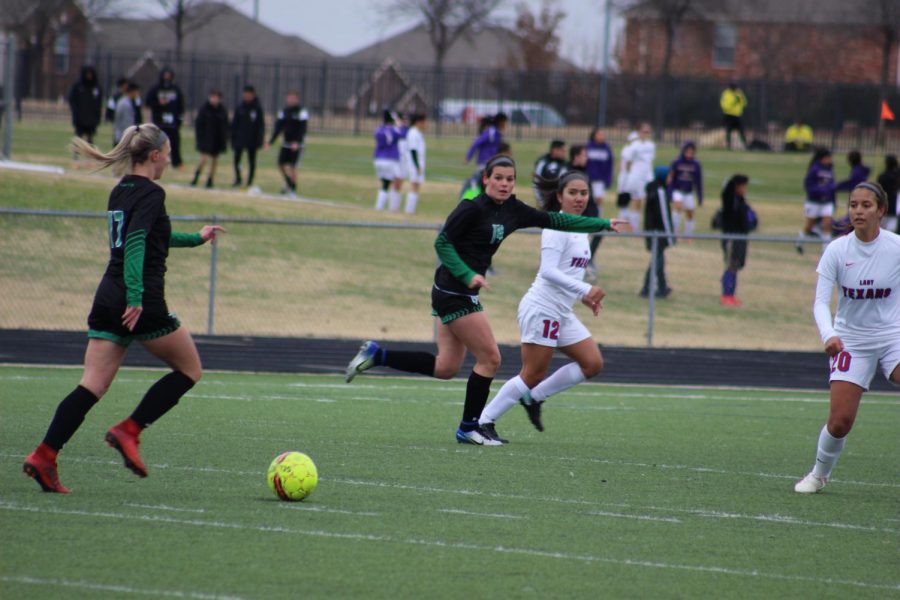 Journie Long and Kara Moore taking the ball to the goal.