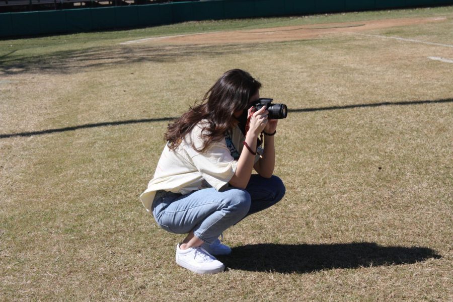 Senior Bailee Johnson taking a photo of the baseball field