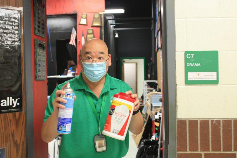 Mr. G shows off his cleaning supplies outside his classroom.
