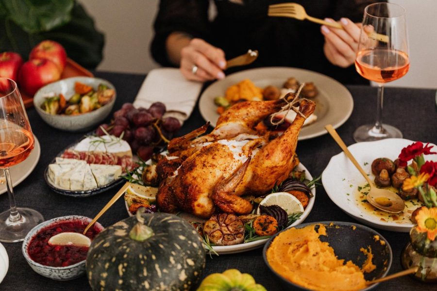 A person is seen sitting at a table eating Thanksgiving food. 
https://www.pexels.com/photo/roasted-turkey-on-white-ceramic-plate-5718104/