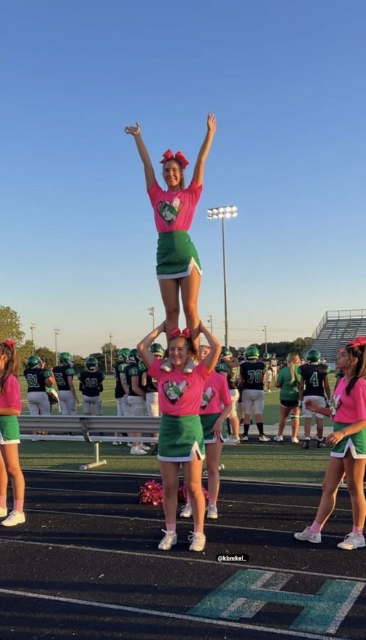 Sophmore Julia Busque in a shoulder stand with Freshman Kayley Brekel at a football game