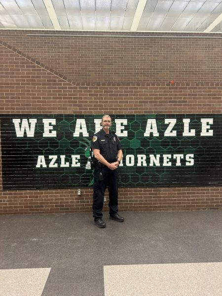 Officer Stutsman stands In front of Azle staircase