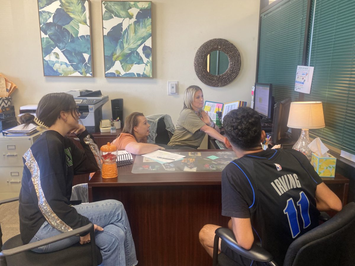 PEIMs clerk Shannon Beauchamp discusses class changes with registrars Kyla Latta and Lydia Easter, and senior Jayson Villalobos.