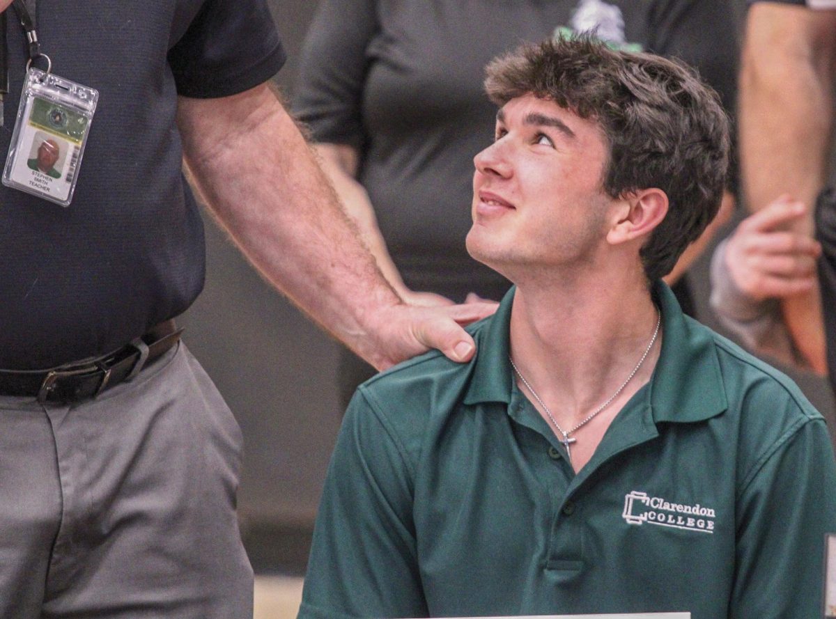 Jake McGee listens to Coach Stephen Smith attest to his accomplishments.