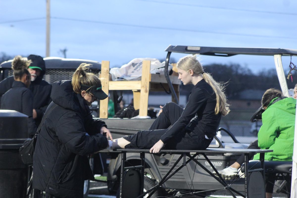 Athletic trainer Christine Hardee helps sophomore Nicole Johnson at a track meet.