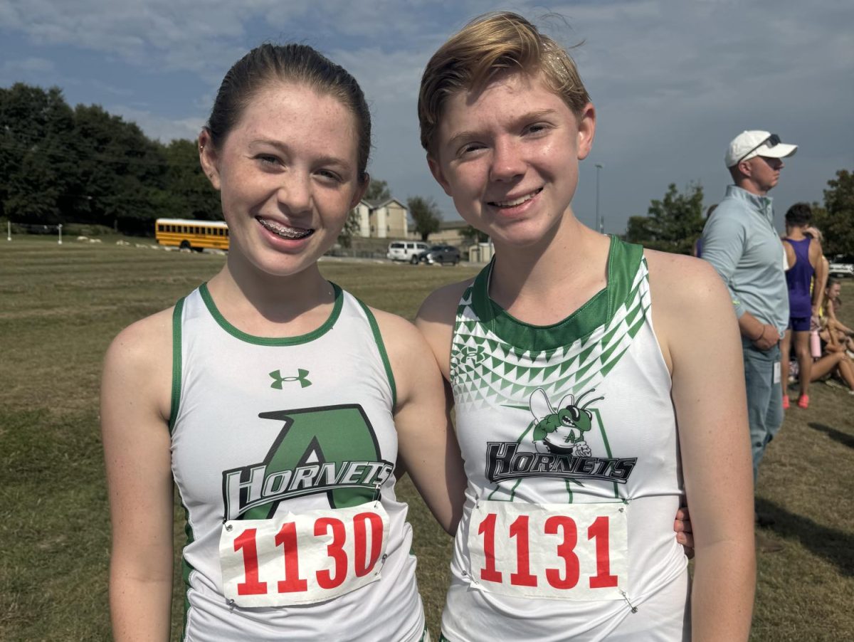 Juniors Eliana and Lily Hudman pose at a cross-country meet.
