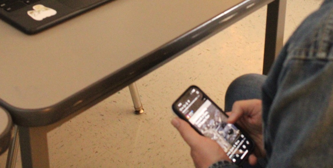 A student sneakily scrolls on social media in class.