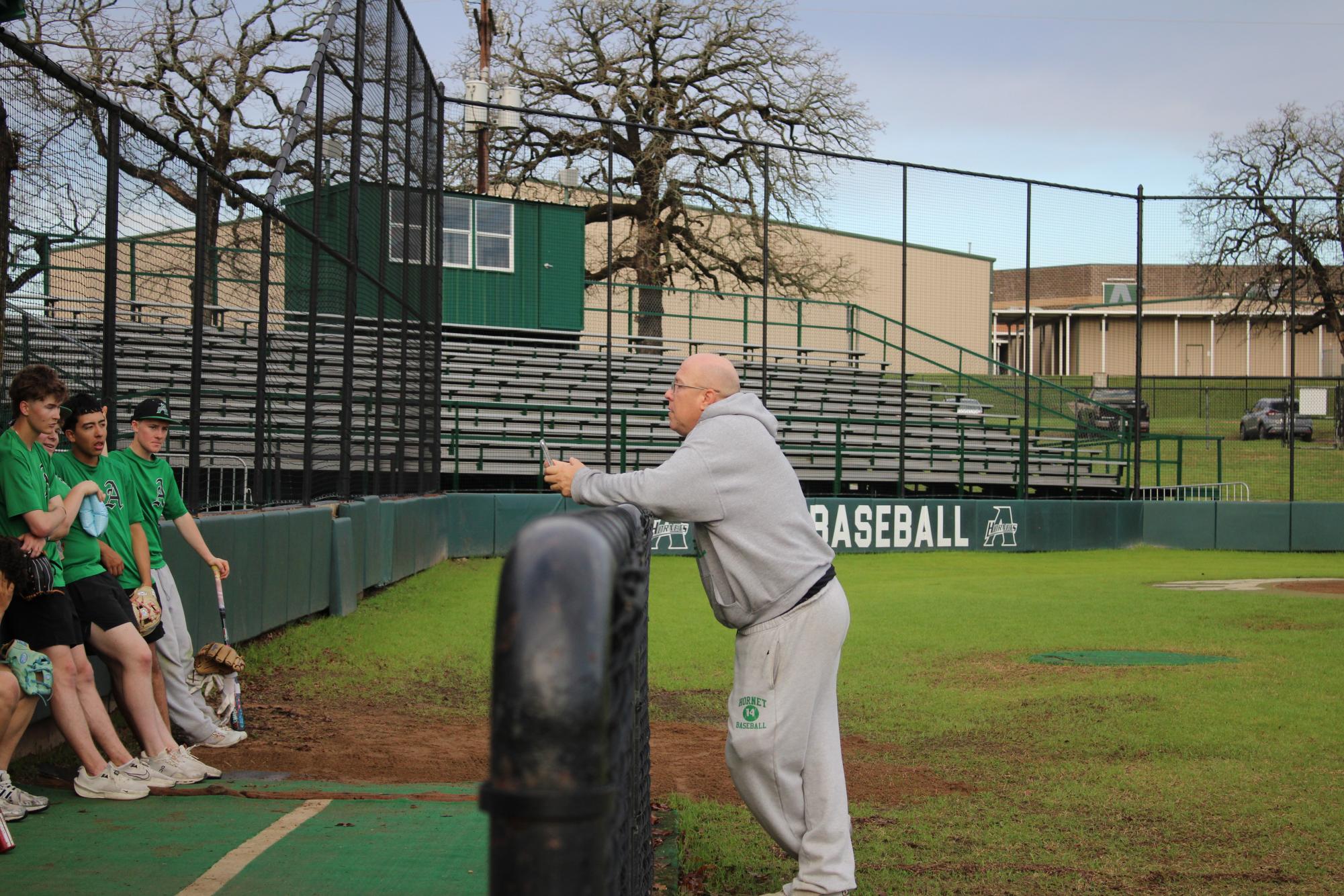 Coach Smith stands talking to his team at practice.